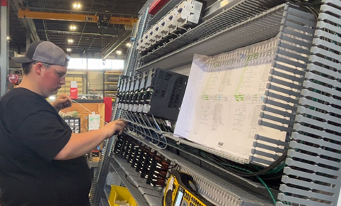 Youth Apprentice wiring a control panel backplate