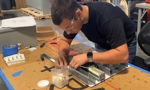 Youth Apprentice learning to wire a backplate